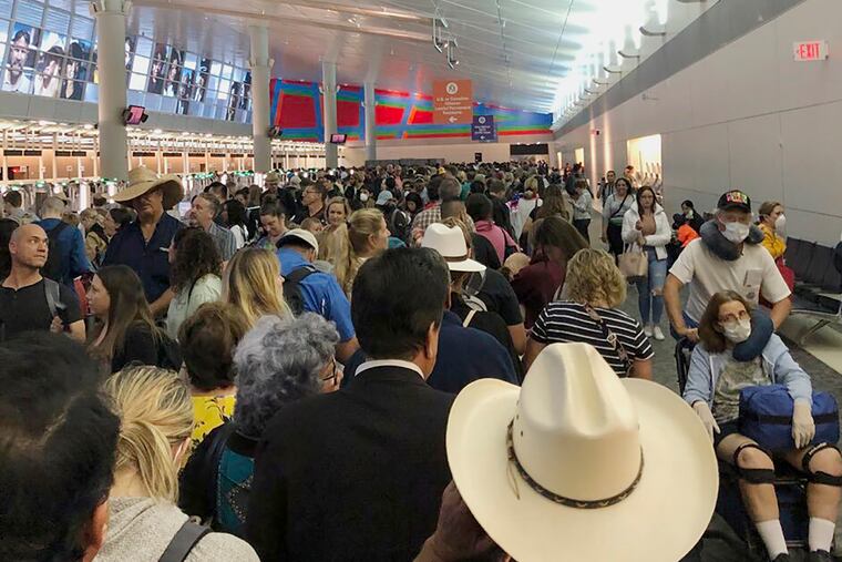 In this photo provided by Austin Boschen, people wait in line to go through the customs at Dallas Fort Worth International Airport in Grapevine, Texas, Saturday, March 14, 2020. International travelers reported long lines at the customs at the airport Saturday as staff took extra precautions to guard against the new coronavirus, The Dallas Morning News reports. Boschen said it took him at least 4 hours to go through the customs. (Austin Boschen via AP)