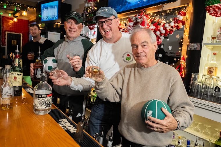 From left, former Daily news sportswriters Bob Cooney, Ed Barkowitz, and Mike Kern at Wolf Burger in South Philadelphia. The bar will host their annual Christmas fundraiser on Friday.