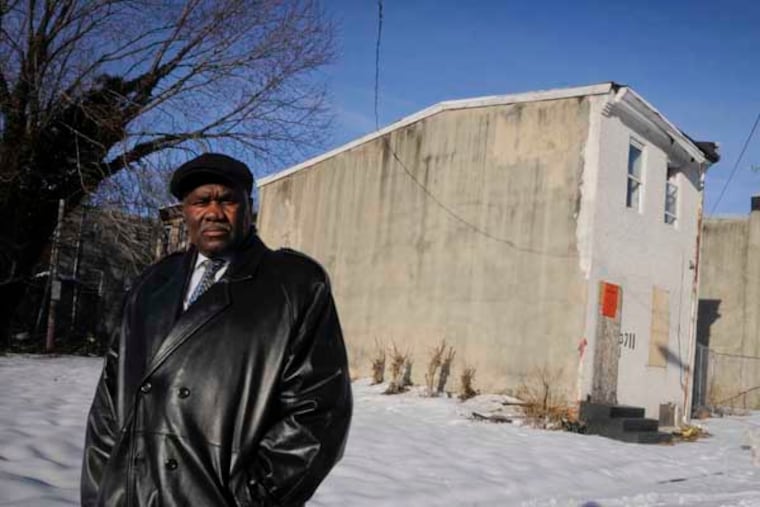 Rev. Harry Moore, pastor of Mount Olive Baptist Church, stands beside a house at 3711 Melon St., in Mantua where he will preside over a "funeral" for the house in an attempt to recognize Mantua's past, embrace its present and celebrate its potential rebirth with the help of a federal Promise Zone. ( RON TARVER / Staff Photographer ) February 17, 2014