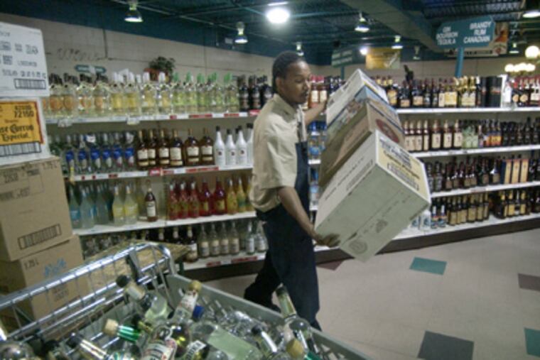 An employee stocks shelves at the Wine & Spirits store at Franklin Mills
Circle. (File Photo)