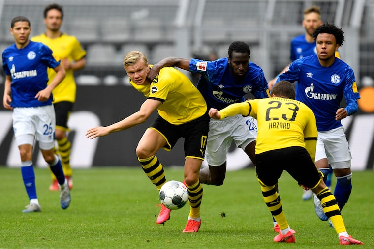 Borussia Dortmund's Erling Haaland (center) tries to keep the ball under pressure from Schalke 04 players, including American midfielder Weston McKennie (far right), last weekend.