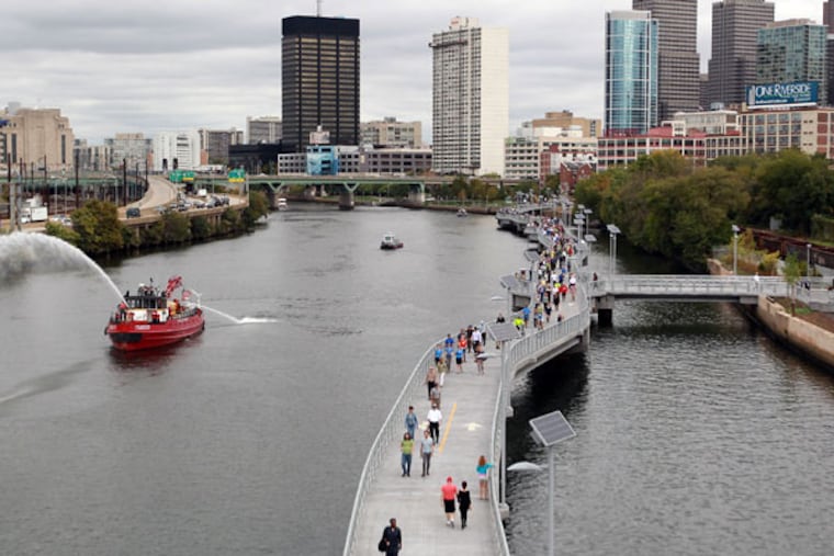 Pedestrians walking on the new Schuylkill Banks Boardwalk stop to enjoy the view during the inaugural opening of the boardwalk on Thursday, Oct. 2, 2014. ( MICHAEL BRYANT / Staff Photographer )