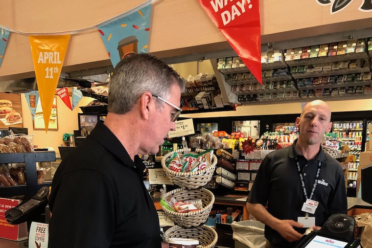 Joe Callahan (left) uses his Binji MasterCard at the Wawa near the offices of his "tech equity" company, Ciright, in Conshohocken