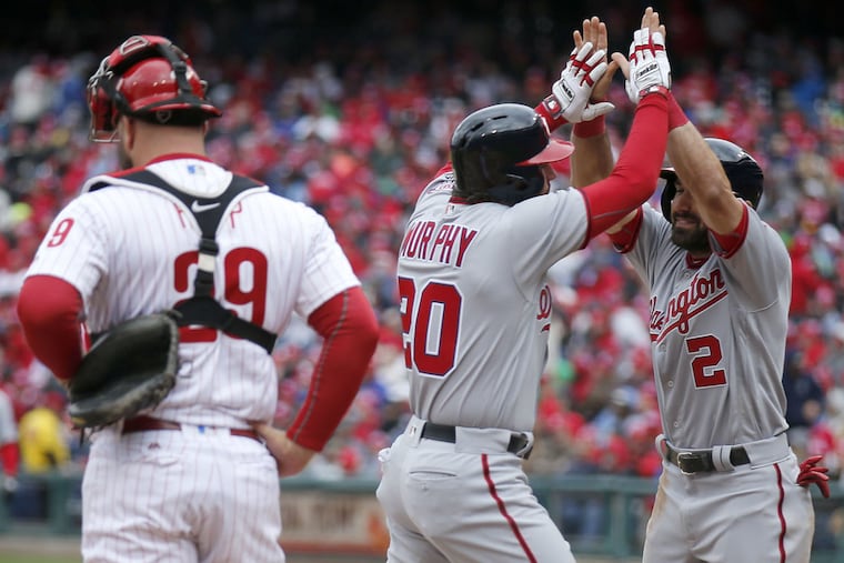 Daniel Murphy (20) of the Nationals celebrates his third-inning home run with teammate Adam Eaton near Phillies catcher Cameron Rupp on Friday, April 7, 2017 in Philadelphia.