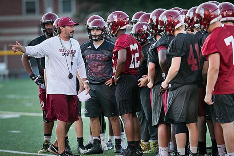 St. Joe's Prep football coach Gabe Infante speaks with players during practice. St. Joseph's Prep football practice at Brady Field, 11th and Cecil B. Moore Ave on Thursday, August 27, 2015.