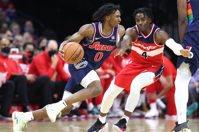 Tyrese Maxey, left, of the Sixers drives against Aaron Holiday of the Wizards during the 2nd half of their game at the Wells Fargo Center on Feb. 2, 2022.