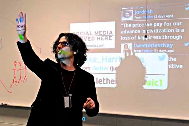 In front of board with projection from LocaModa.com, which gathers and displays Twitter feeds, (his is JORDOSH, just above & to right of his head) Jordan Shapiro (cq) teaches his philosophy class at Temple University February 13, 2013. He not only allows smart phones in class, but asks his students to tweet their thoughts and reactions during class. Headline of a piece he wrote for Forbes.com: "Colleges Shouldn't Be Jittery About Students Who Are Twittery" ( TOM GRALISH / Staff Photographer )