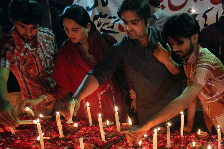 Pakistanis light candles for the victims of a bombing attack on churches in Karachi last year.