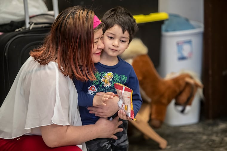 Suyapa Reyes, left, gives her son, Jeison, 4, a hug in the room they share at the First United Methodist Church of Germantown. The mother of four is able to leave the church, live and work in the United States.