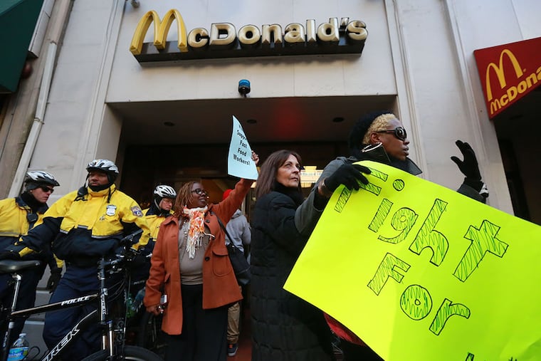 Protesters demonstrate for a higher minimum wage outside McDonald's on Walnut Street on Thursday, December 4, 2014. ( DAVID SWANSON / Staff Photographer )