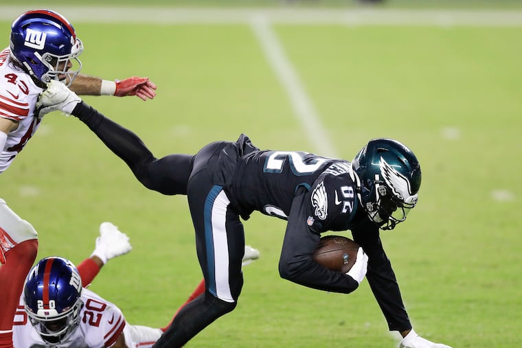 Eagles wide receiver John Hightower lunges forward after catching a fourth-quarter pass past Giants defensive back Nate Ebner and free safety Julian Love on Thursday.