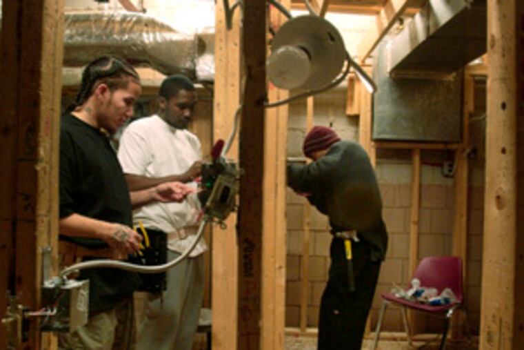 Orleans Technical Institute students (from left) Victor Bellmon, Antonio Williams and Rashene Stephens install switches and sensors. Supporters say a bill requiring licensing for electricians and telecom workers is long overdue for public safety. Opponents say it will hurt small contractors and raise costs.