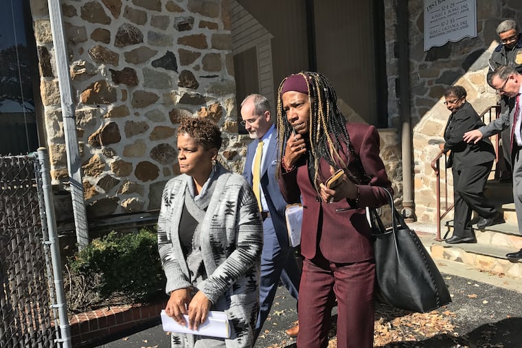 Gloria Byars, left, her sister Carolyn Collins (on steps, in back) and Keith Collins (on steps above his wife) walk out of the district court in Havertown, Pa., on Monday, Oct. 21, 2019, after bail hearings. They remained in custody and were being led by Delaware County authorities to a holding cell in Upper Darby before being transported to the Delaware County Prison in Thornton. The person in the burgundy suit walking next to Byars is unidentified.