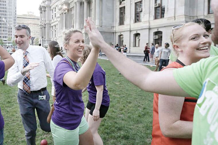 "Bocces Be Trippin" team members (L-R facing camera) James Healy (white shirt), Elizabeth Schroeder and Kendra Darigan (all of Phila) high five "Bocce Bitch" team member Robert Welz of Phila after playing bocce on Dilworth Park at Philadelphia City Hall on August 12, 2015. ( ELIZABETH ROBERTSON / Staff Photographer )