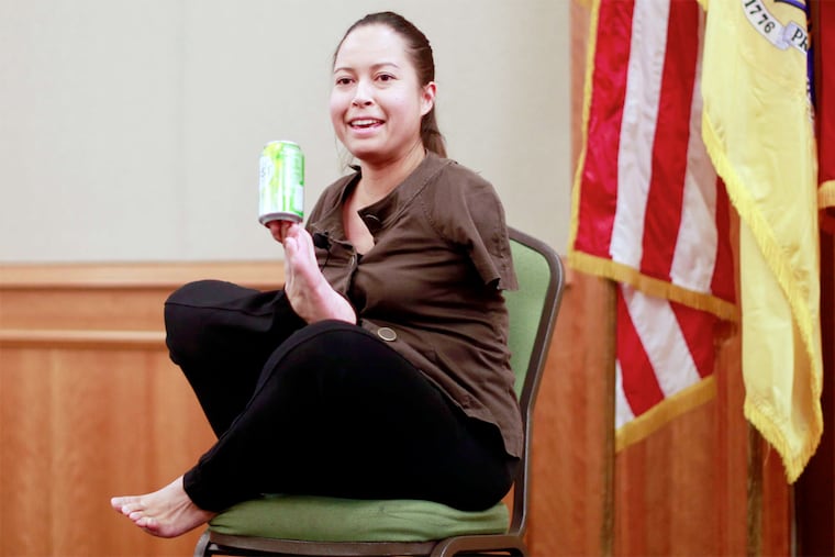 Jessica Cox shows how she opens and drinks a can of soda using her feet at Rutgers-Camden.
