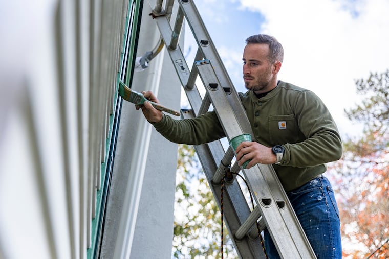 Sean O’Donnell, the resident caretaker and restorer of the Knight Park House in Collingswood, is painting the original cedar trim on the 134-year-old structure.