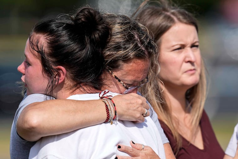 People embrace at a makeshift memorial after a shooting last week at Apalachee High School in Winder, Ga.