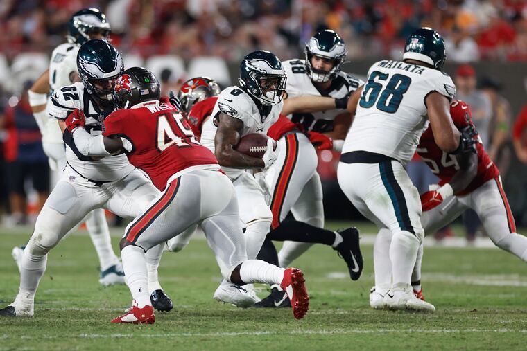Eagles running back D'Andre Swift finds an opening as center Jason Kelce (left) blocks Tampa Bay's Devin White on Monday.