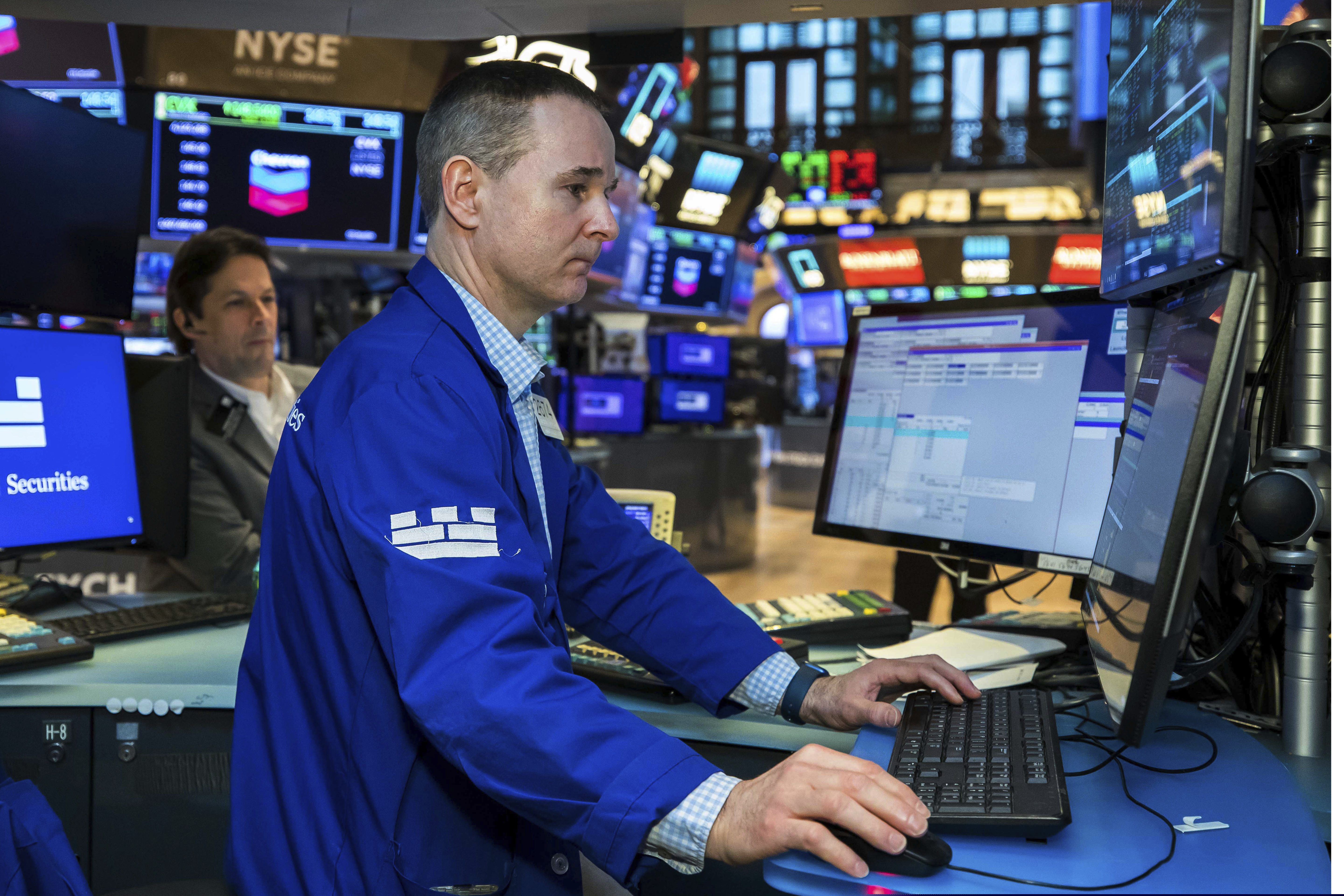 In this photo provided by the New York Stock Exchange, specialist Stephen Naughton works at his post on the trading floor Tuesday.