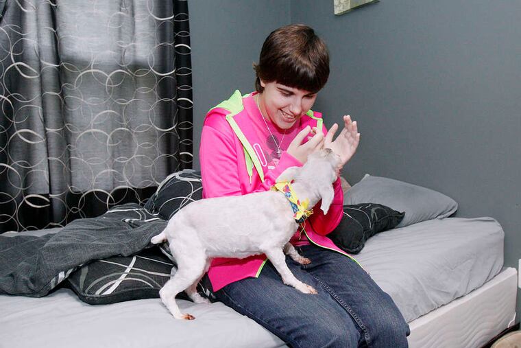 Stephanie Kier, 21, plays with Lucie the dog. She's preparing for life as an adult in a house her mother bought with money raised through their family nonprofit, Stephanie's House. AKIRA SUWA / Staff Photographer