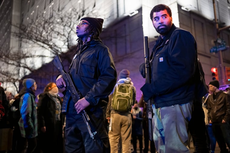 Armed members of the Black Panther Party for Self-Defense, including Paul Birdsong (right), stand among the crowd of protesters as they march throughout Center City on Thursday, Jan. 8, 2026, to rally against the killing of Renee Nicole Good, who was shot by an ICE agent in Minneapolis.