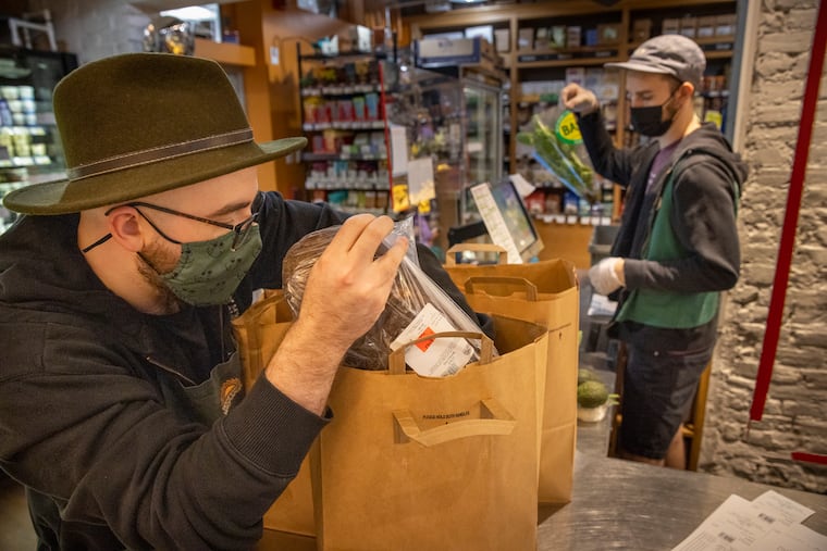 Alec Cuthbert, Home Delivery Coordinator at Weavers Way Co-op, bags an order for home delivery from the store in Mount Airy.