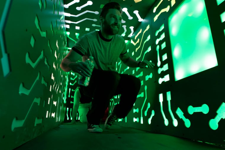 A visitor crawls through a secret tunnel at Otherworld in Northeast Philly, which was ranked one of USA Today's "10 Best New Attractions" of 2024.