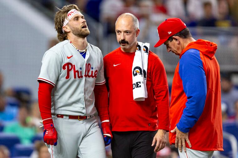 The Phillies' Bryce Harper reacts after getting hit by a pitch on his right elbow by Marlins pitcher Braxton Garrett on Saturday.