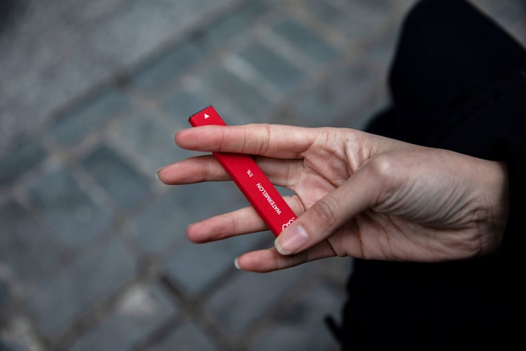 In this January file photo, a woman holds a Puff Bar flavored disposable vape device in New York. U.S. health officials are cracking down on the brand of fruity disposable e-cigarettes that is popular with teenagers, saying the company never had permission to launch in the U.S. The Food and Drug Administration sent a letter Monday, July 20 telling the maker of Puff Bar e-cigarettes to remove its products from the market, including flavors like Mango, Pink Lemonade and Strawberry.