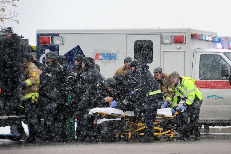 Emergency crews transport an officer to an ambulance in the heat of the siege at a Planned Parenthood clinic in Colorado Springs. The shooting lasted hours before officers persuaded the gunman to surrender.