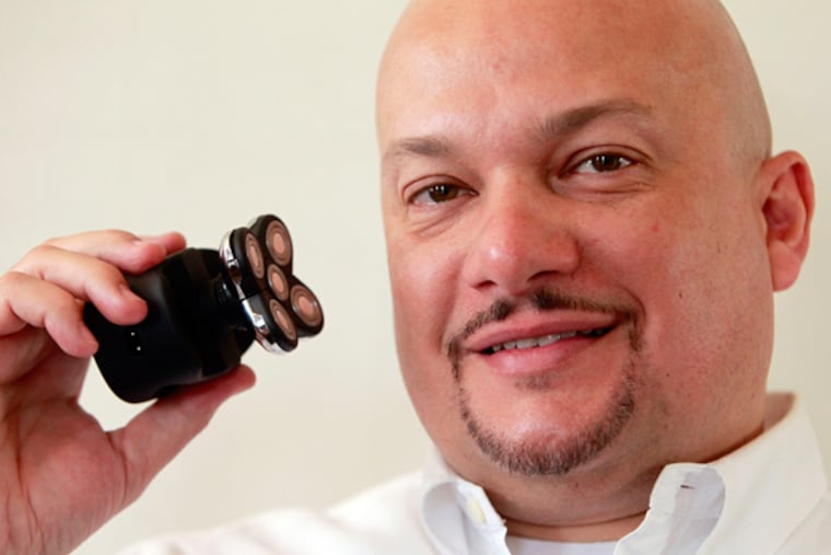 John Lyles shows his product -- the Skull Shaver. With his clean pate, he found a need for such a product himself. (Akira Suwa / Staff Photographer)