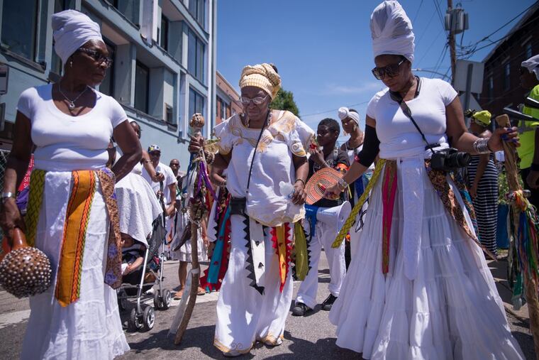 Iya Olakunbe Oludia, a member of the Wilmington, Delaware chapter of the Ifa religion, leads a procession down Grays Ferry Avenue during the Odunde festival, June 11th, 2017.