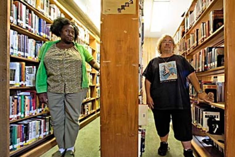 Ethel Randall (left) and Barbara Park have worked together at the Fairview branch for 18 years. They’ll move to different libraries. (DAVID M WARREN / Staff Photographer)