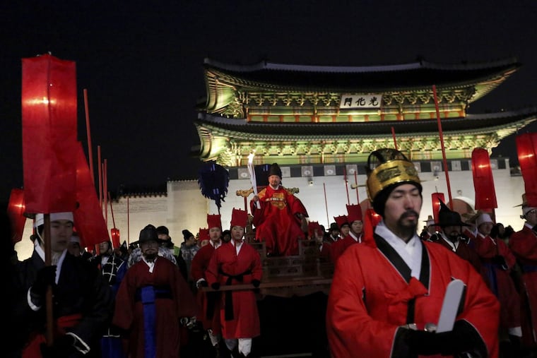 A torch bearer wearing traditional costumes carries the torch during the Olympic Torch Relay in Seoul, South Korea, Saturday, Jan. 13, 2018. South Korea said Saturday that North Korea proposed that their talks next week address a North Korean art troupe’s visit to the Pyeongchang Winter Olympics in the South, rather than the participation of the nation’s athletes.