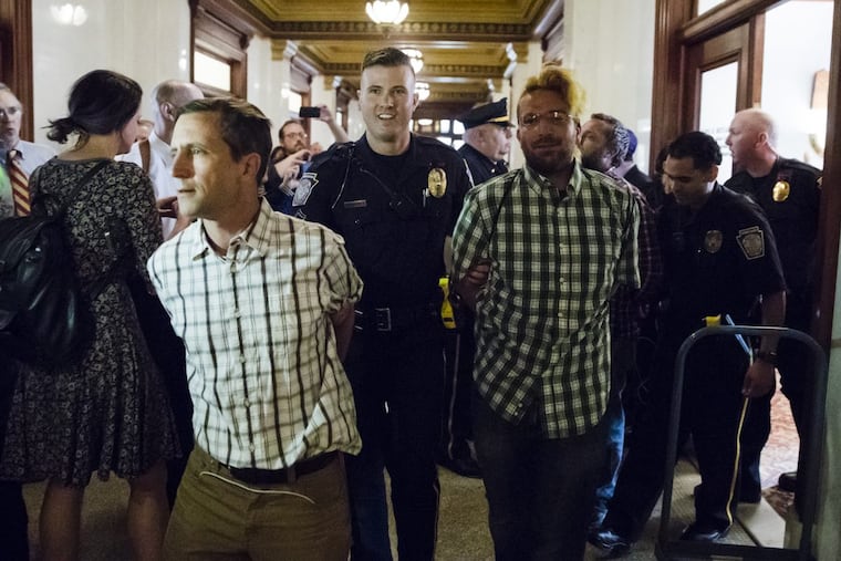 Demonstrators seeking a ban on gifts to lawmakers are taken away from the office of House State Government Committee Chairman Daryl Metcalfe, a Republican, after being arrested at the Pennsylvania Capitol in Harrisburg, Pa., Tuesday, May 23, 2017. The March on Harrisburg demonstrators say they want a gift-ban bill that's been sitting in Metcalfe's committee since January to move forward. Group members say Metcalfe refuses to meet. (AP Photo/Matt Rourke)