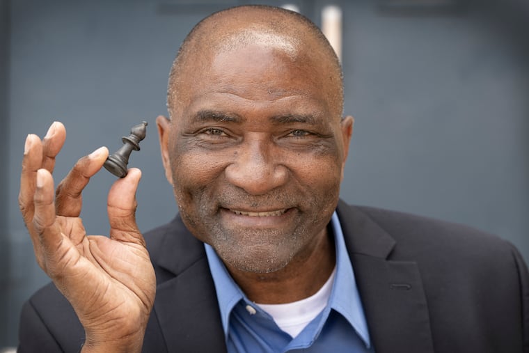 Salome Thomas-EL holds a bishop chess piece near the Vaux Big Picture High School, formerly Vaux Middle School, in Philadelphia. The former Vaux principal used chess to foster a strong student life at the North Philadelphia school, and developed a chess team that became nationally famous. His book, "I Choose to Stay," discusses his educational philosophy and the importance of teachers remaining in tough situations.