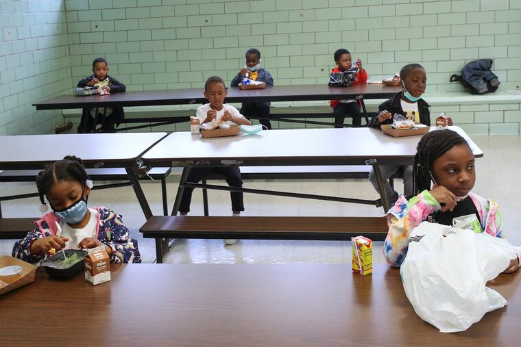 Students sit socially distant as they eat lunch in the cafeteria at William Dick Elementary in North Philadelphia in May.