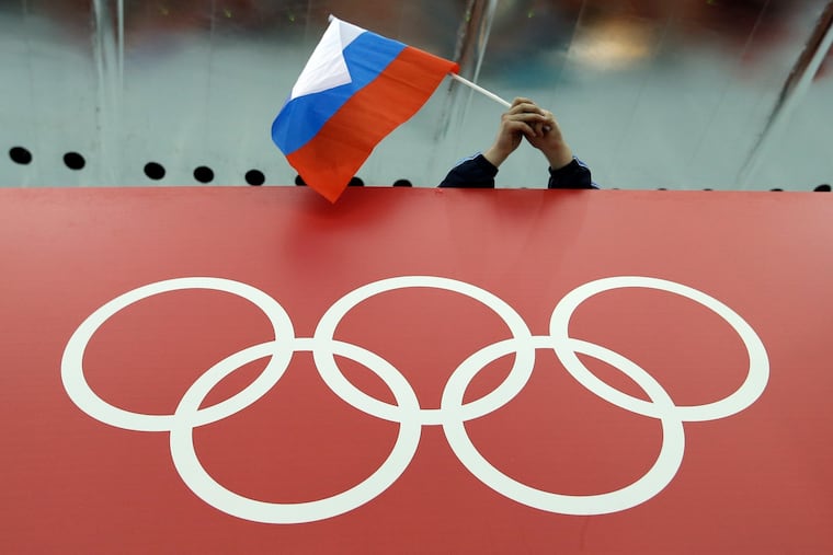 In this Feb. 18, 2014 file photo, a Russian skating fan holds the country's national flag over the Olympic rings before the men's 10,000-meter speedskating race at Adler Arena Skating Center during the Winter Olympics in Sochi, Russia. A person familiar with the case tells The Associated Press that Russia's anti-doping agency could face suspension again based on information indicating data from the Moscow drug-testing lab had been manipulated before being delivered to the World Anti-Doping Agency earlier this year.