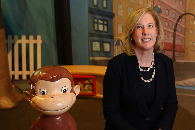 Patricia Wellenbach, CEO of the Please Touch Museum, poses with Curious George at the museum.