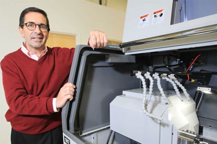 Christopher J. Kneizys , president and CEO of Micro-Coax Inc., in Pottstown, shows a Swiss CNC screw machine, which cuts parts for the connectors that the company makes. (Charles Fox / Staff Photographer)