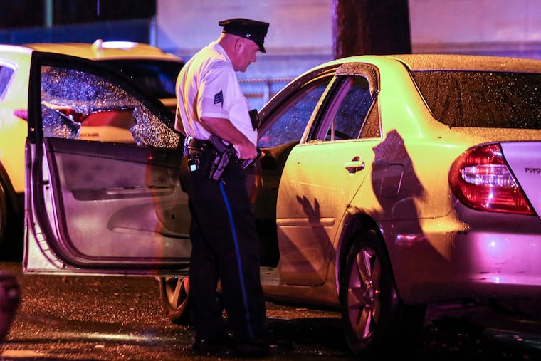 A police sergeant on the 3500 block of North 21st Street looks over a car where a man was shot. He was transported to Temple University Hospital, where he died a short time later. Thursday, Sept. 22, 2021