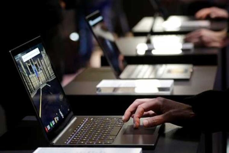 People test the the Google Chromebook Pixel laptop after an announcement in San Francisco, Thursday, Feb. 21, 2013. Google is adding a new touch to its line of Chrome laptops in an attempt to outshine personal computers running on software made by rivals Microsoft and Apple. (AP Photo/Jeff Chiu)