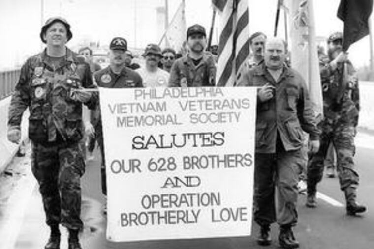 Vietnam vets returning from Washington, where they traced the names of what, at the time, were believed to be the 628 Philadelphians who died in Vietnam and who were listed on the Vietnam memorial wall, march across the Platt Bridge on their way to Veterans Stadium in May 1987.