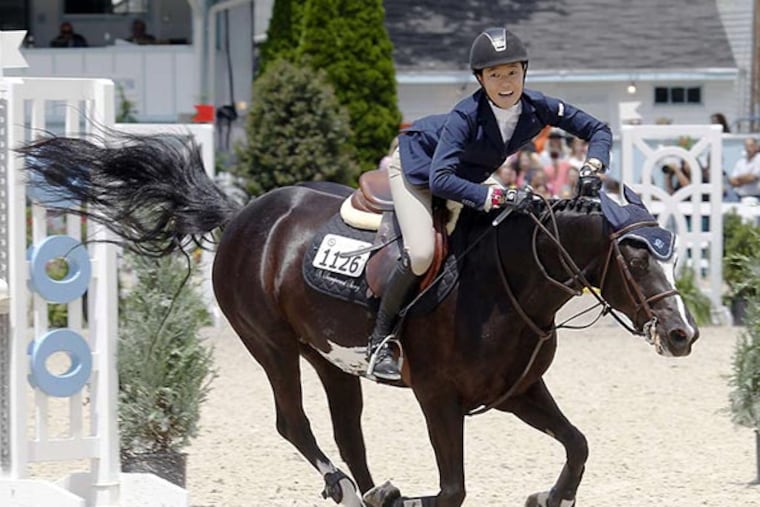 Merrill Harvey lands safely with her horse after jumping a hurdle in the pony jumper event at the Devon Horse Show. AKIRA SUWA / Staff Photographer