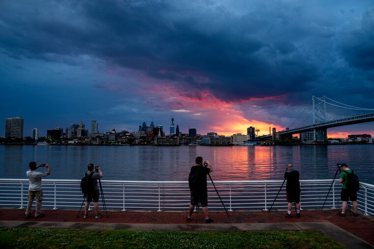 Photographers capture the sunset over Philadelphia from the Camden Waterfront, following the passing of a fast-moving evening thunderstorm and a June tornado warning.