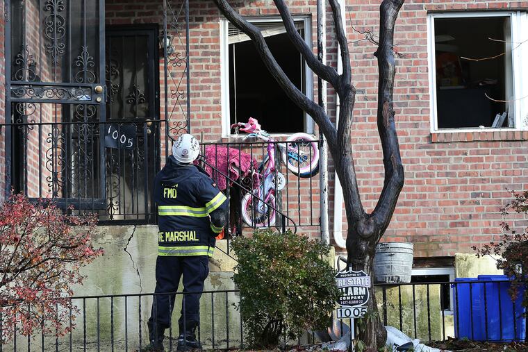 A fire marshal examines the scene of a fire at 1005 Medary Ave. in Philadelphia on Tuesday, Dec. 22.