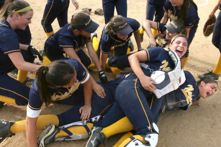 Winning pitcher Erica Cipolloni (right) and catcher Alicia Keough (second from right) join the pileup of bodies as Nazareth Academy players celebrate their Catholic Academies softball championship after defeating Villa Maria, 3-0.