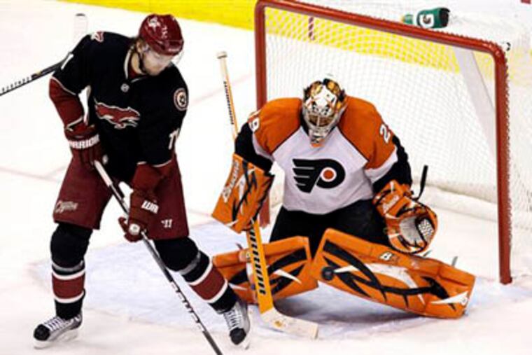 Philadelphia Flyers' Ray Emery, right, makes a save on a shot as Phoenix Coyotes' Martin Hanzal looks to catch the rebound in the third period. The Coyotes defeated the Flyers 3-1. (AP Photo/Ross D. Franklin)