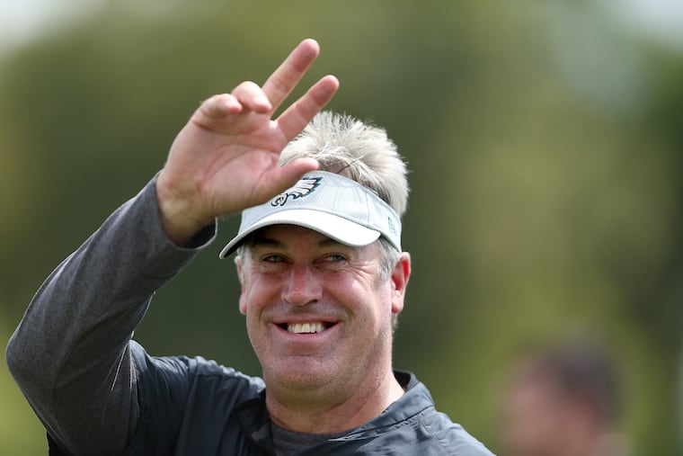 Eagles' head coach Doug Pederson waves to a fan during Eagles training camp in Philadelphia, PA on August 14, 2018. DAVID MAIALETTI / Staff Photographer