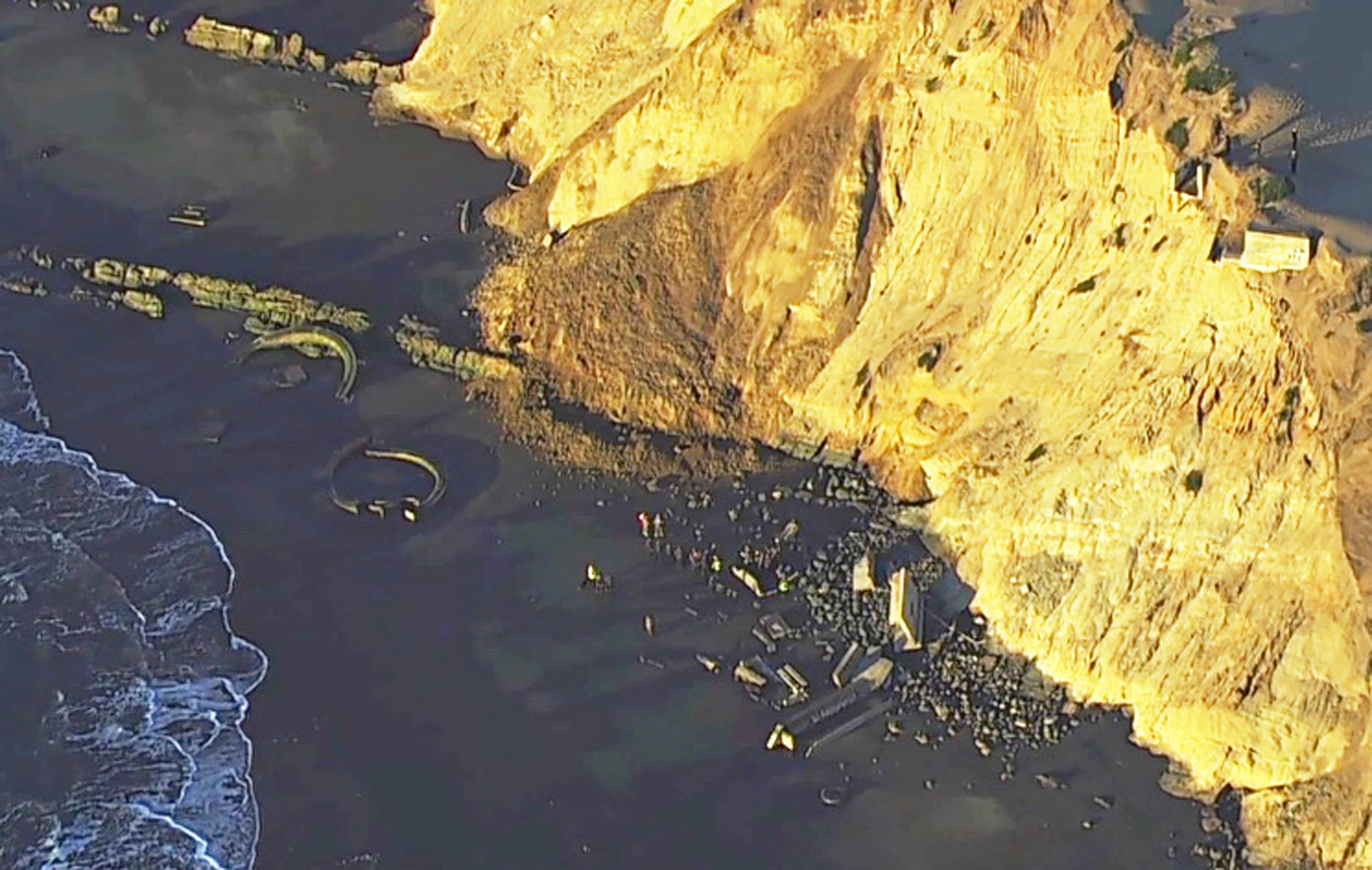 This photo from video provided by KGO-TV shows firefighters searching for a person who was thought to be buried by a landslide near a San Francisco beach Friday, Feb. 22, 2019. San Francisco Fire Department spokeswoman Mindy Talmadge said two people were walking along the shoreline when a cliff and hill gave way. (KGO-TV via AP)